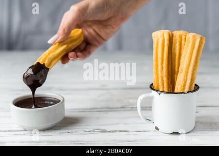 Churros mit Schokolade, ein traditionelles spanisches Dessert mit Süßspeisen. Stockfoto