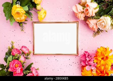 Goldener Rahmen für Fotografie, Blumen, rosafarbener Hintergrund mit Glitzereffekt. Flach, lat. Draufsicht. Platz für Text Stockfoto