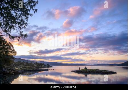 Blick auf den Sonnenaufgang von Massacre Bay vom Pebble Cove Farm Inn auf Orcas Island, Washington. Stockfoto