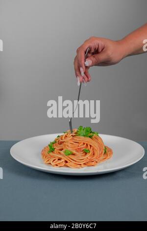 Spaghetti in roter Soße mit Schweinehinken Stockfoto