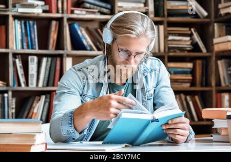 Pensive Young Sit Studienbibliothek Lesen Buch hören Hörbuch Bildungskonzept Stockfoto