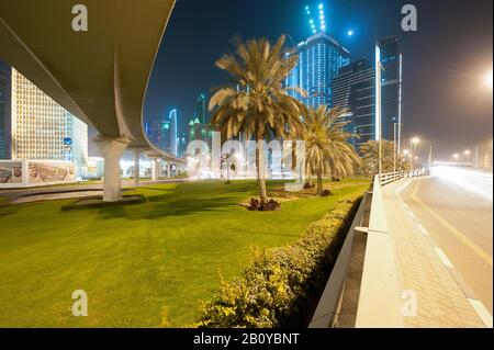 Brücke und Autobahnkreuz am World Trade Center Roundabaout an der Scheich Zayed Road mit Blick auf Hochhäuser in der Nacht, Downtown Dubai, Vereinigte Arabische Emirate, Stockfoto