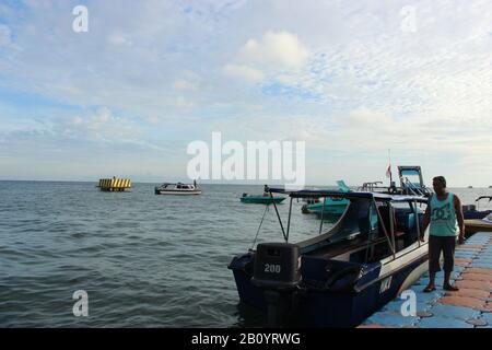 Mann und Boot am Tanjung Batu Port Stockfoto