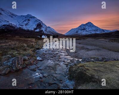 Sonnenuntergang über dem Coupall River und Lagangarbh Cottage in Glen Coe, Scottish Highlands, Schottland Stockfoto