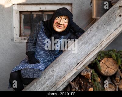 Ein Mann, der eine Maske trägt, nimmt während des Karnevals Teil.Traditioneller Karneval in Sappada, einer deutschsprachigen Stadt in den Dolmiti-Bergen in Italien, wo die Menschen noch immer ihren altmodischen deutschen Mundart verwenden, ist an drei Sonntagen aufgeteilt: Sonntag der Armen, Sonntag der Bauern und Sonntag der Herren. Die Menschen tragen traditionelle Holzmasken namens "Love" und spielen lustige Charaktere, um Nachbarn und Besucher zu unterhalten. Die wichtigste Maske ist Rollat, ein riesiger Mann in Schaftfellmantel mit Holzgesicht des Hirten. Stockfoto