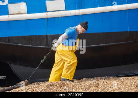 Hastings Fischer hilft, Trawler an Land auf der Altstadt von Stade bei Rock-a-Nore, East Sussex, Großbritannien zu ziehen Stockfoto