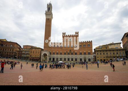 Blick auf das mittelalterliche Gebäude des Rathauses des Palazzo Publico an der Piazza del Campo an einem bewölkten Tag. Siena, Italien Stockfoto