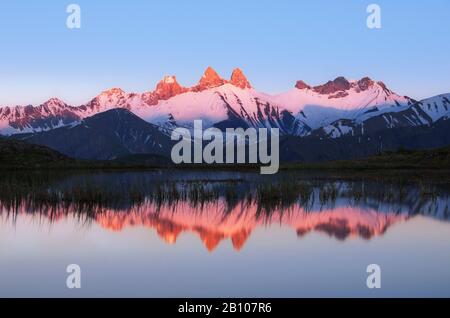 Berggipfel mit Alpenglow in den französischen Alpen spiegelten sich im Bergsee, Aiguille d'Arves, Hautes-Alpen, Alpen, Frankreich, wider Stockfoto