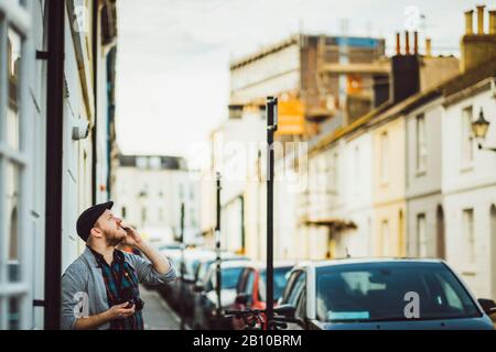 Der Mann auf der Straße blickt auf den Himmel, Brighton, England Stockfoto