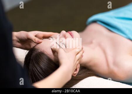 Junge schöne Frau, die nach der Massage im Spa liegt und sich entspannt Stockfoto