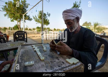 Saharauische Wüstenmenschen spielen Dominosteine vor einem Teehaus in einer Oase, Ägypten Stockfoto