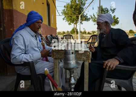 Saharauische Wüstenmenschen spielen Dominosteine vor einem Teehaus in einer Oase, Ägypten Stockfoto