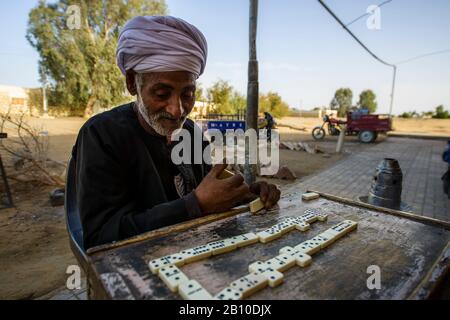 Saharauische Wüstenmenschen spielen Dominosteine vor einem Teehaus in einer Oase, Ägypten Stockfoto