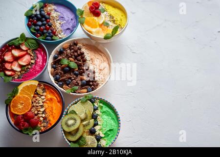 Verschiedene gesunde frische Smoothies oder Yogurts in Schüsseln. Mit Erdbeeren, Kiwi, chia, Brombeeren Stockfoto