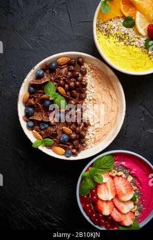 Verschiedene gesunde frische Smoothies oder Yogurts in Schüsseln. Mit Erdbeeren, Kiwi, chia, Brombeeren Stockfoto