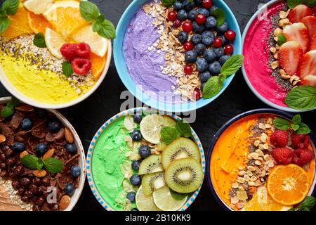 Verschiedene gesunde frische Smoothies oder Yogurts in Schüsseln. Mit Erdbeeren, Kiwi, chia, Brombeeren Stockfoto