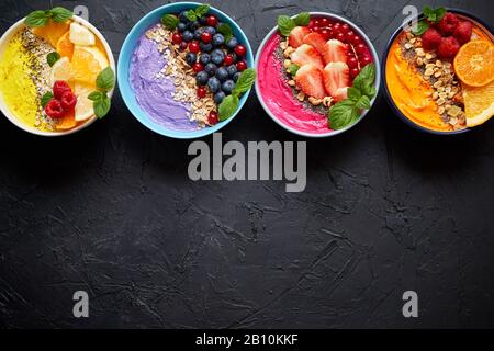 Verschiedene gesunde frische Smoothies oder Yogurts in Schüsseln. Mit Erdbeeren, Kiwi, chia, Brombeeren Stockfoto