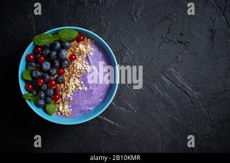 Gesundes Lebensmittelkonzept. Frisches Obst, Blackberries und Currants, Joghurt oder Smoothie mit Hafer und Flocken Stockfoto