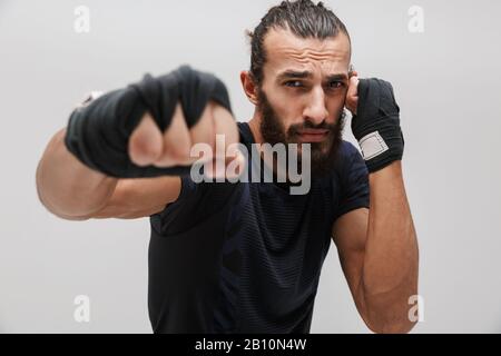 Bild des jungen brutalen Mannes im Sportwehboxen und Blick auf die Kamera isoliert über weißem Hintergrund Stockfoto