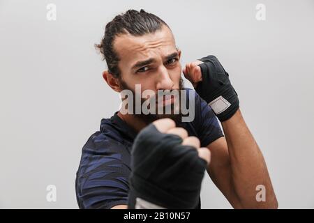 Bild des jungen brutalen Mannes im Sportwehboxen und Blick auf die Kamera isoliert über weißem Hintergrund Stockfoto