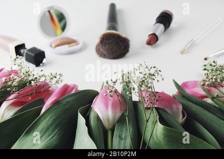 Bereit für die Liebe. Schöne Frühlingsblumen Tulpen-Blumenstrauß mit Kosmetik für Grüße auf weißem Hintergrund. Copyspace. Petalen und Blätter, bilden Kompos Stockfoto