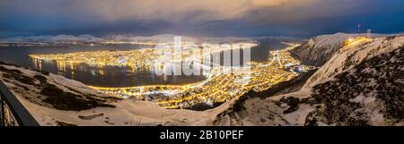 Blick von Fjellheisen über die schneebedeckten, nächtlichen Tromsø, Norwegen Stockfoto