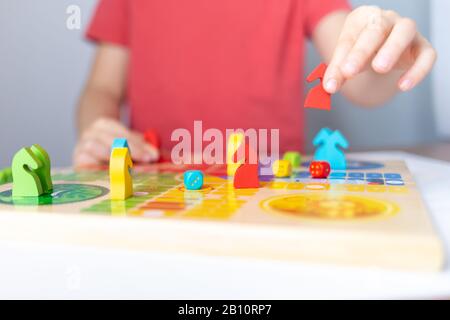 Spielekonzept, bunte Figuren in Kinderhand Stockfoto