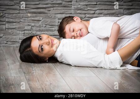 Mutter und Sohn kuscheln auf dem Boden Stockfoto