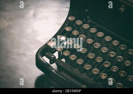 Staubige Vintage-Schreibmaschine steht auf dem Tisch. Stockfoto