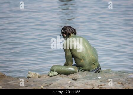 Touristen, die Schlamm aus dem Toten Meer anwenden, der die medizinischen Qualitäten besitzt und den Menschen mit Hautproblemen hilft. Körperpflege in Israel. Stockfoto