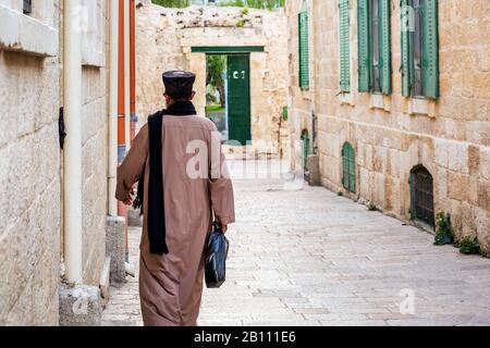 Äthiopisch-orthodoxe Priester an der Kirche an der äthiopischen Sektion des Heiligen Grabes in Jerusalem. Jerusalem, Israel. Rückansicht. Stockfoto