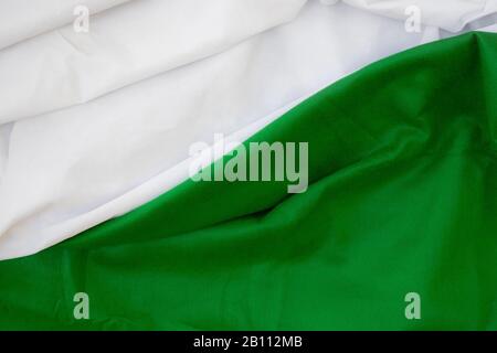 Stoffwellen schließen den Hintergrund, Gestapeltes, Knitterförmiges Material 3-farbig schwarz-grün-weiß, elegantes Tapeten-Design, gewellte Falten von grunger Seidentextur saßen Stockfoto