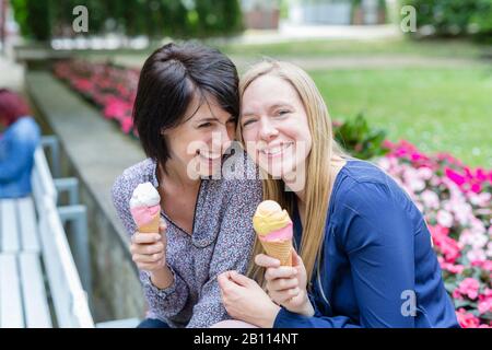 Zwei Freunde lachen zusammen und essen Eis Stockfoto