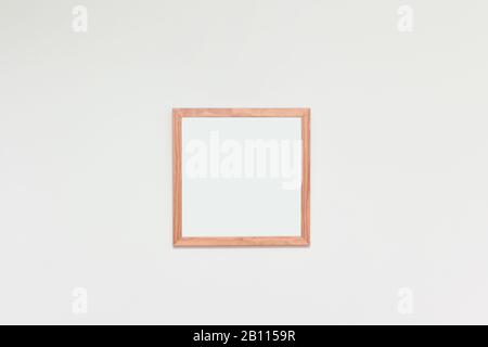 Leerer Bilderrahmen mit Leerplatz für Foto oder Kunst an einer weißen Innenwand Stockfoto