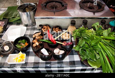 Kochklasse, verschiedene Gewürze in Schüsseln rund um den alten Gasherd auf dem Tisch. Indonesien Bali Essen. Stockfoto