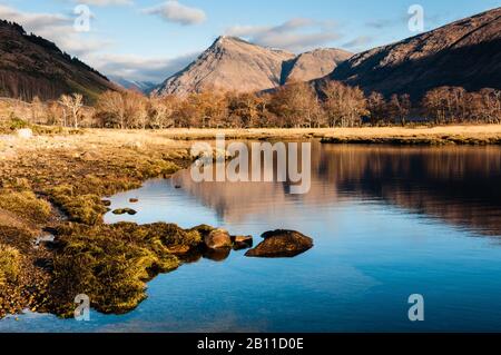 Bäume und Berge spiegelten sich Anfang Dezember im Kopf von Loch Etive, Schottland, wider Stockfoto