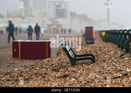 Hove UK 22. Februar 2020 - Die Bänke an der Küste von Hove sind fast vollständig von Schindel bedeckt, der durch die jüngsten Stürme aufgeworfen wurde. Das stürmische Wetter wird sich in den nächsten Tagen in ganz Großbritannien fortsetzen und es wird mit weiteren Überschwemmungen und Schäden gerechnet: Credit Simon Dack / Alamy Live News Stockfoto