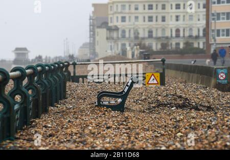 Hove UK 22. Februar 2020 - Die Bänke an der Küste von Hove sind fast vollständig von Schindel bedeckt, der durch die jüngsten Stürme aufgeworfen wurde. Das stürmische Wetter wird sich in den nächsten Tagen in ganz Großbritannien fortsetzen und es wird mit weiteren Überschwemmungen und Schäden gerechnet: Credit Simon Dack / Alamy Live News Stockfoto