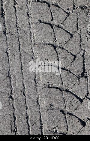 Reifenabdrücke auf der sandigen Straße in Schwarzweiß Stockfoto