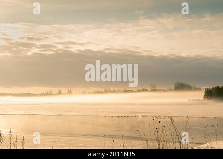 Der Nebel erhebt sich über den gefrorenen Dunk River im ländlichen Prince Edward Island, Kanada. Stockfoto