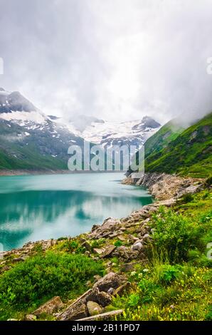 Schöne alpine Landschaft mit Bergsee am bewölkten Tag. Vertikales Foto. Stockfoto