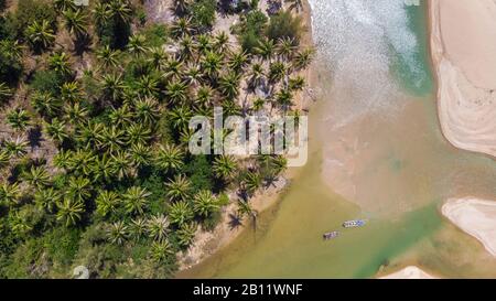 Luftaufnahme des ruhigen Flusses, der Boote und Kokospalmen entlang des Khao Lak Strandes in Thailand Stockfoto