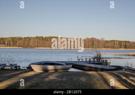 Boote in der Nähe der Anlegestelle am See, Lettland Stockfoto