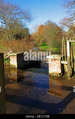 Ein Seitenkanal und ein Wehr zur Kontrolle des Wasserspiegels in Letheringsett Watermill bei holt in North Norfolk bei Letheringsett, Norfolk, England, Großbritannien, Europa. Stockfoto