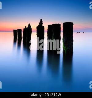 Sonnenuntergang am Westrand, Steinpyramiden an der alten Groyne, Darß, Ostsee, Mecklenburg-Vorpommern, Deutschland Stockfoto