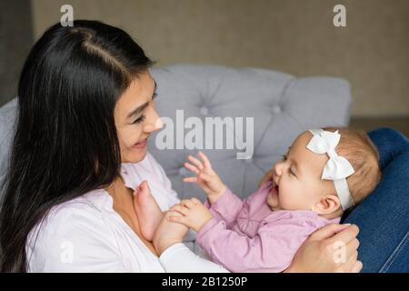 Mutter sitzt mit Baby auf einem Stuhl Stockfoto