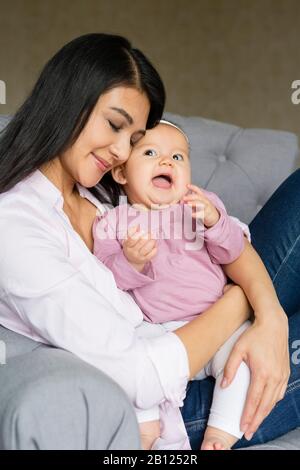Mutter sitzt mit Baby auf einem Stuhl Stockfoto
