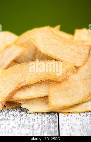 Scheiben getrockneter Melone. Pommes aus Melone auf einem weißen Holztisch Stockfoto