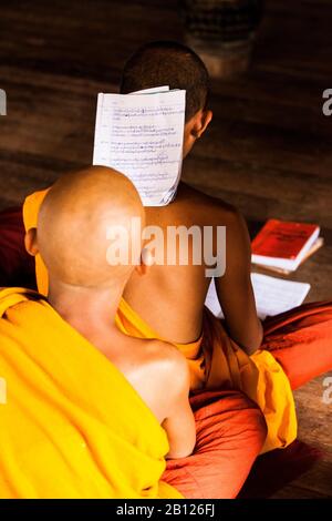 Novizenmönch, der auf dem Rücken eines anderen Monchs im Kloster Shwe Yaunghwe Kyaung studiert. Myanmar Stockfoto