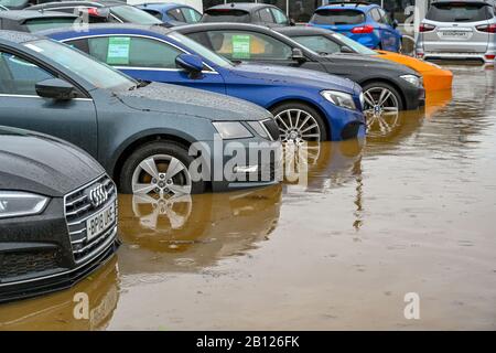 TREFOREST INDUSTRIEGEBIET, IN DER NÄHE VON CARDIFF, WALES - FEBRUAR 2020: Autos zum Verkauf auf dem überfluteten Vorplatz des Evans Halshaw Autohauses in Wales Stockfoto